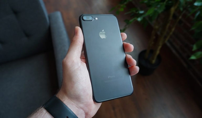 Elinde akıllı telefon tutan ve mesajlarına bakan kişi